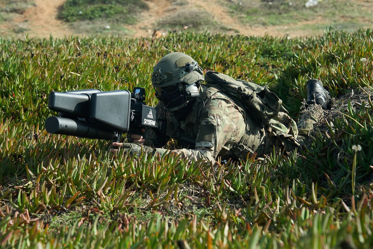 Soldier operating portable counter-drone system in field environment